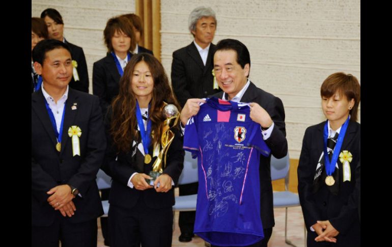 El primer ministro, Naoto Kan (2d), sostiene una camiseta firmada  junto a las jugadoras Homare Sawa (2i) y Aya Miyama (d). EFE  /