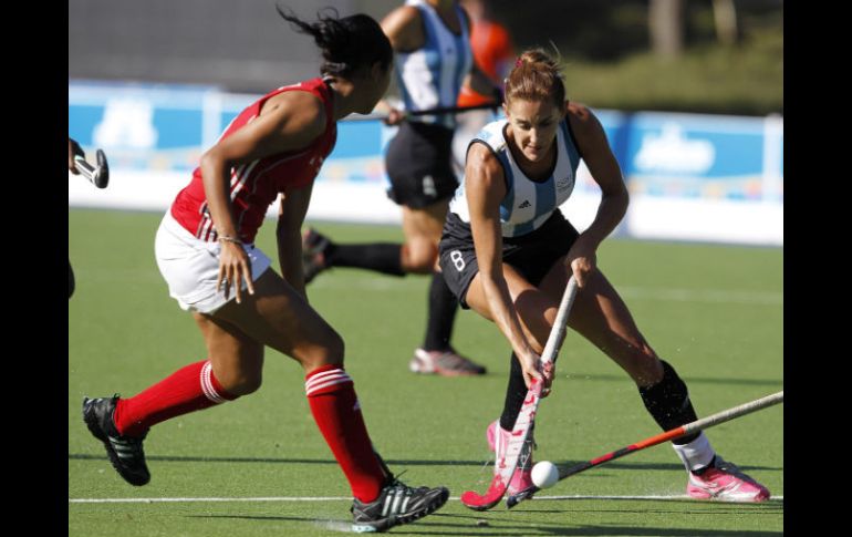 Luciana Aymar, de Argentina, abriéndose paso entre sus rivales de Trinidad. REUTERS  /