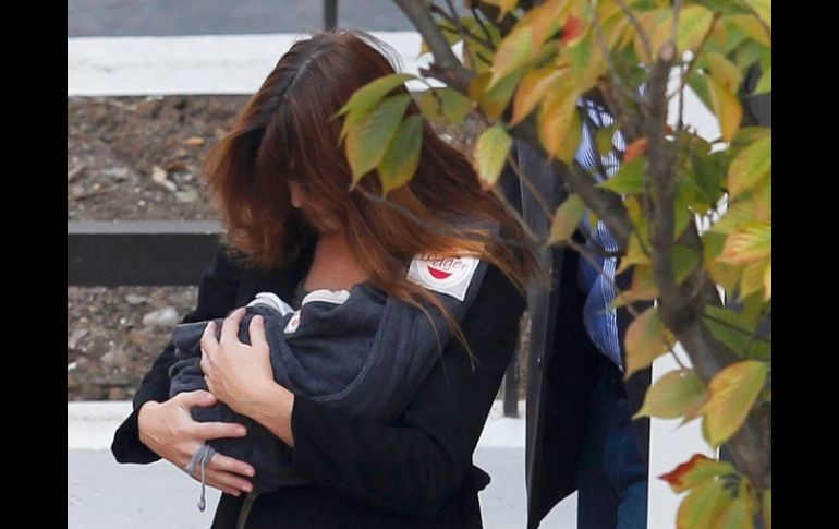 Carla Bruni carga a su bebé al salir hoy de la clínica de maternidad en París. REUTERS  /