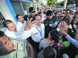 Policías y personal del Copag intentan calmar a la gente que esperaba entrar al Complejo de Volibol.  /