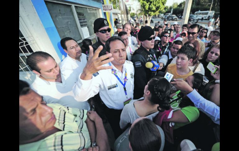 Policías y personal del Copag intentan calmar a la gente que esperaba entrar al Complejo de Volibol.  /