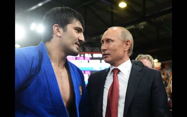 El presidente de Rusia, Valdimir Putin (D), conversa con el judoca Tagir Khaibulaev (I).  /