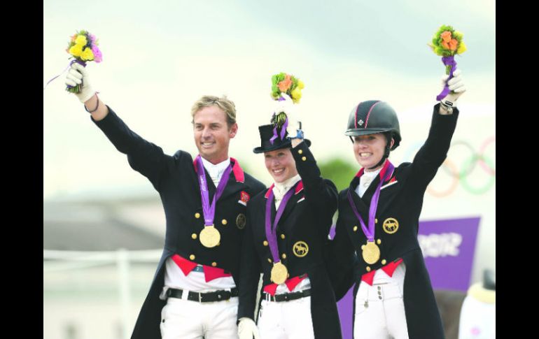 Carl Hester, Laura Bechtolsheimer y Charlotte Dujardin celebran el primer lugar tras recibir su medalla de oro. XINHUA  /