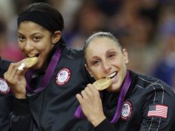 Diana Taurasi (D) y Candace Parker muerden sus medallas de oro durante la ceremonia. AP  /