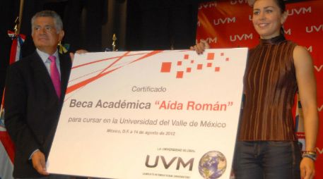 El rector de la UVM, Dieter Holtz, entrega la beca educativa a la medallista mexicana Aída Román. NOTIMEX  /