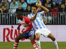 El delantero de Granada Odion Ighalo (i) lucha la posición del defensa del Málaga Weligton de Oliveira. EFE  /