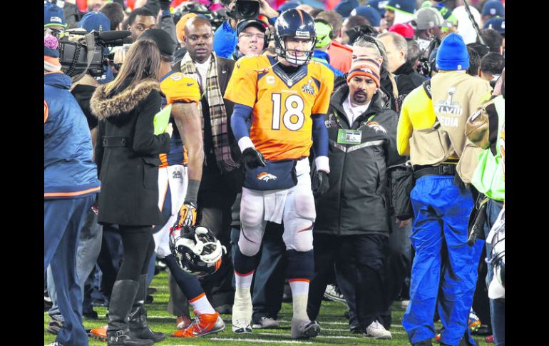 Cara larga. Peyton Manning se retira del emparrillado, rodeado de fotógrafos. EFE /