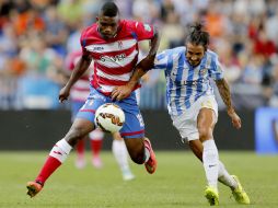 El delantero del Granada, Jhon Andrés Córdoba (i), disputa el balón con el defensa del Málaga, Marcos Alberto Angeleri (d). EFE / J. Zapata