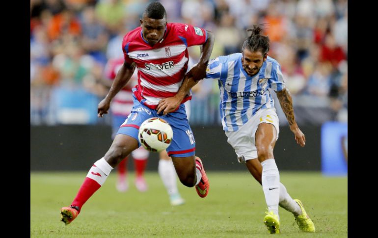 El delantero del Granada, Jhon Andrés Córdoba (i), disputa el balón con el defensa del Málaga, Marcos Alberto Angeleri (d). EFE / J. Zapata