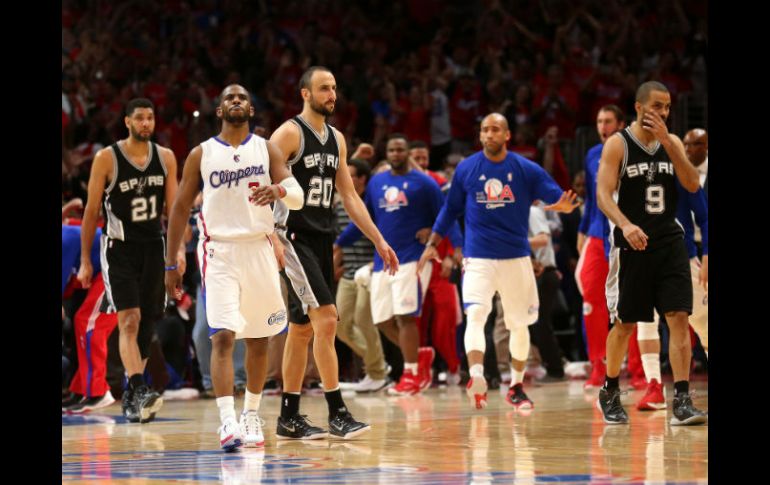 Manu Ginóbili (20) mira cómo el balón lanzado por Chris Paul (de blanco) se mete a la canasta. AFP / S. Dunn