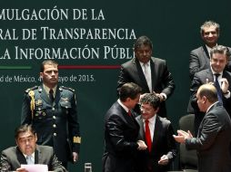 El Presidente Enrique Peña Nieto es felicitado por el secretario de la Función Pública, Virgilio Andrade, tras la promulgación. SUN / J. Boites