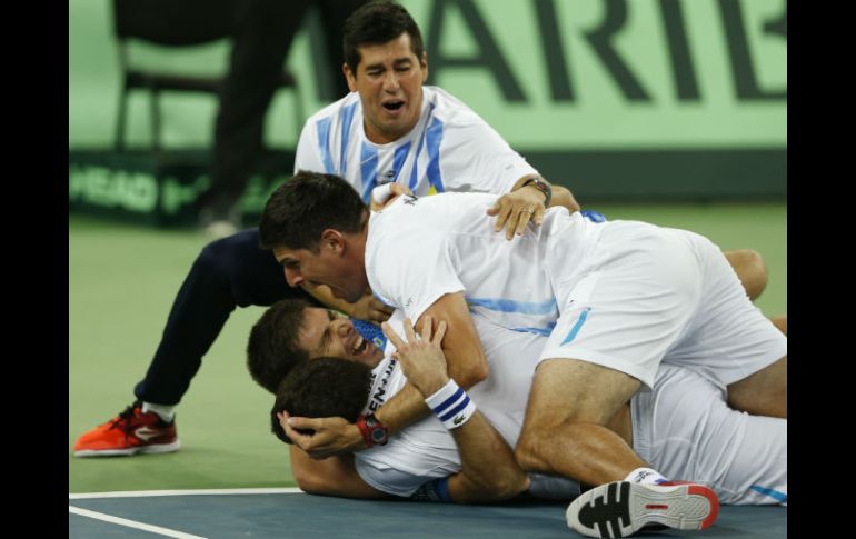 Federico Delbonis (segundo de abajo hacia arriba) celebra la victoria con sus compañeros de equipo. AP / D. Vojinovic