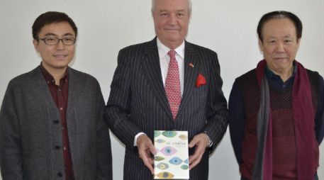 El embajador Jorge Heine (c); el hispanista Wen Ran (i), y el profesor universitario y traductor Zhao Zhenjian, posan hoy con el libro. EFE / R. Cañas