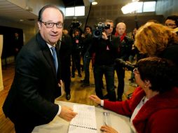 El mandatario saludó a todos los presentes en el colegio electoral y recibió una rosa de una mujer. EFE / R. Duvignau