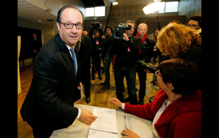 El mandatario saludó a todos los presentes en el colegio electoral y recibió una rosa de una mujer. EFE / R. Duvignau