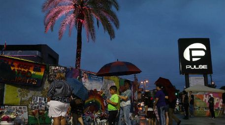 En el exterior del local, numerosas personas se acercaron para recordar a sus amigos caídos y a dejar flores y velas. AFP / J. Raedle