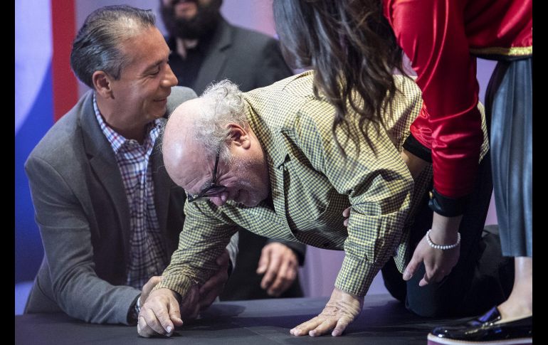 El actor estadounidense Danny DeVito recibe ayuda tras caerse durante una conferencia de prensa en Ciudad de México para promover la película 