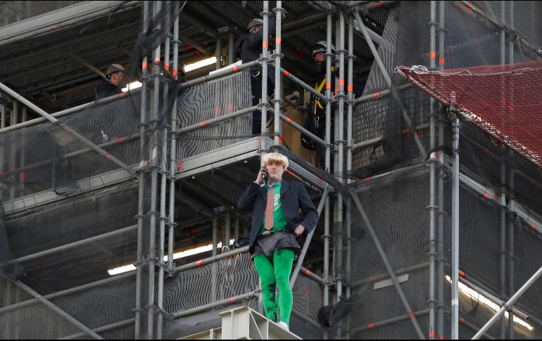 Tras subir sin protección por andamios instalados en Houses of Parliament, sede del parlamento británico, el militante disfrazado de Boris Johnson desplegó pancartas. AP/K. Wigglesworth