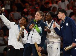 Prisca Awiti (izquierda) se toma una foto con la ganadora del oro Andreja Leski (con franja verde) de Eslovenia, así como las medallistas de bronce Clarisse Agbegnenou (de blanco)  y Laura Fazliu (de azul),  en la premiación de ayer en los Olímpicos de París 2024. XINHUA/W. Wei