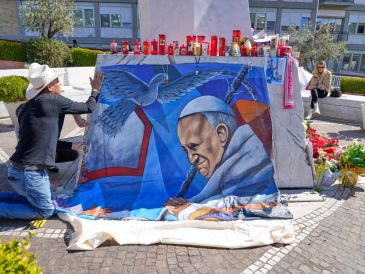 El pintor mexicano Roberto Márquez colocó un retrato del Papa Francisco afuera del Hospital Gemelli de Roma. AP