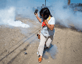 Una manifestante huye del gas lacrimógeno lanzado por agentes federales de inmigración para despejar el camino a los vehículos durante una redada en la zona agrícola de Camarillo, California, el jueves 10 de julio de 2025. AP /ARCHIVO