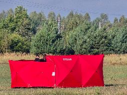 Bomberos aseguran partes de un dron derribado por las autoridades polacas en un lugar en Czosnowka. AP/P. Pyrkosz