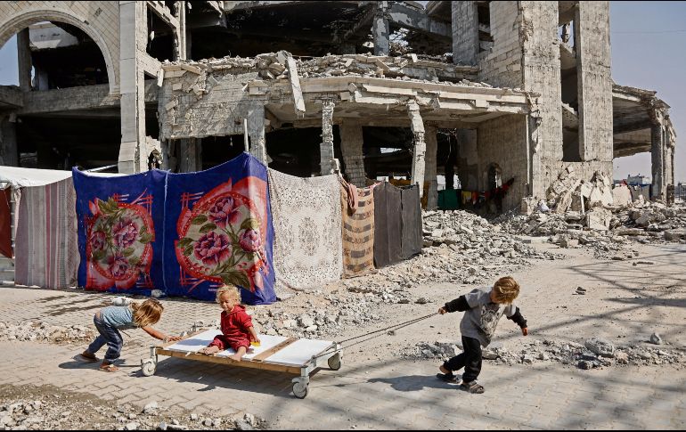 Un grupo de niños juega entre los escombros de la ciudad palestina, ajenos a la tensión entre Israel, Hamás y Estados Unidos. AFP