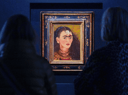 Los visitantes observan la pintura de Frida Kahlo titulada 