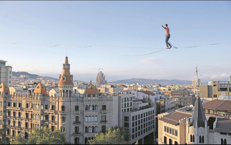 El artista francés Nathan Paulin camina sobre una cuerda en la Plaza de Cataluña, en Barcelona, como parte del Festival Grec, en julio de 2023. AFP/L. Gene