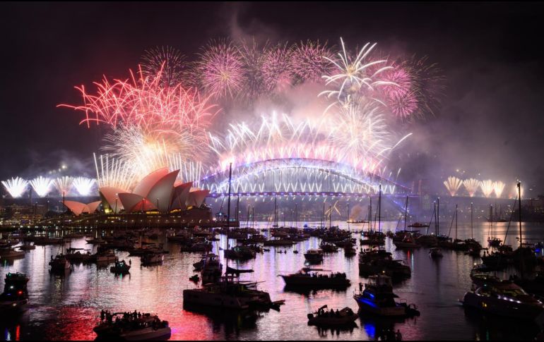 Fuegos artificiales se ven sobre el puerto de Sídney durante el espectáculo de medianoche de Nochevieja, en Mrs Macquaries Point en Sídney. EFE / D. Himbrechts