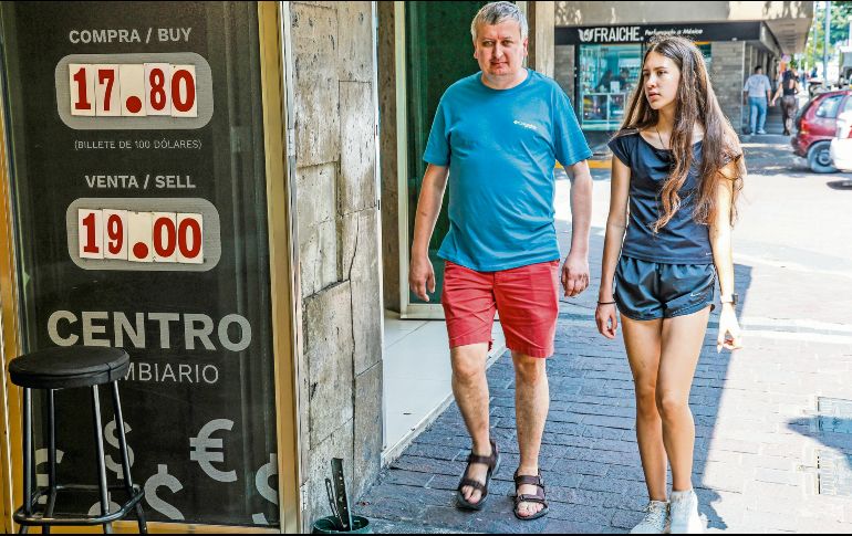 Personas caminan frente a una casa de cambio en la ciudad, mientras se observan operaciones de remesas. EL INFORMADOR/ A. Navarro