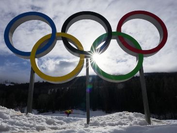 Un atleta esquía bajo los aros olímpicos durante un entrenamiento de cross country antes de los Juegos Olímpicos de Invierno en Tesero, Italia el jueves 5 de febrero del 2026. (AP Foto/Kirsty Wigglesworth)