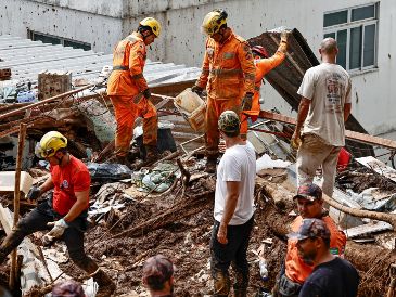 Integrantes del equipo de Bomberos y voluntarios remueven escombros durante las labores de rescate en una zona afectada por fuertes lluvias de Brasil. EFE/ A. Coelho