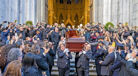 Músicos, principalmente trombonistas, tocan música mientras el cuerpo de Willie Colón sale de la iglesia de San Patricio en Nueva York. EFE