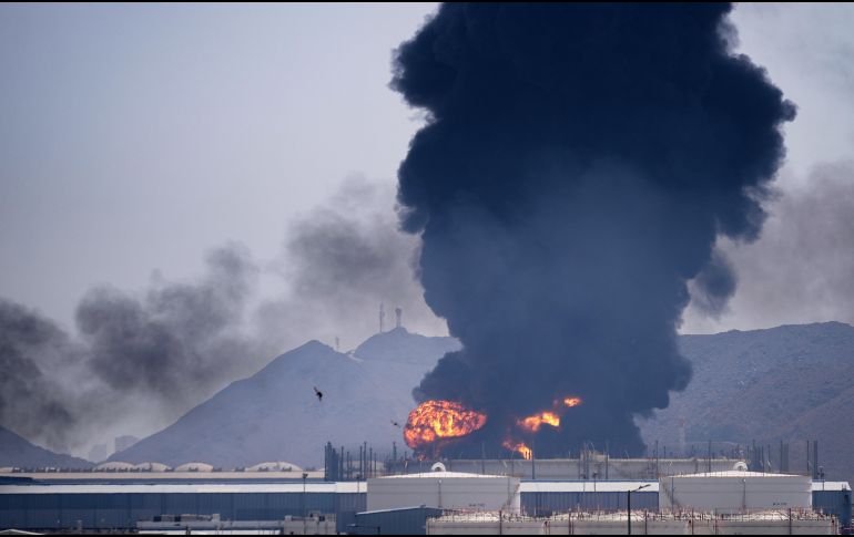 Una llamarada y una columna de humo se elevan tras el impacto de los restos de un dron iraní interceptado contra una instalación petrolera en Fujairah, Emiratos Árabes Unidos. AP/A. Qadri
