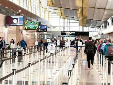 Viajeros transitan por filtros de seguridad con menor afluencia en el Aeropuerto Ronald Reagan de Washington, tras el pago de salarios atrasados a agentes de seguridad, lo que ayudó a reducir filas. AFP