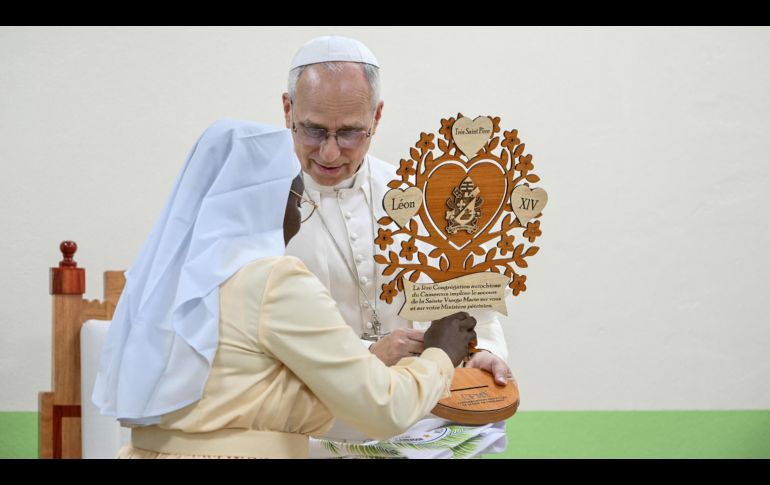 Una religiosa le da un obsequio al papa León XIV durante su visita en Camerún. EFE/A. Pizzoli