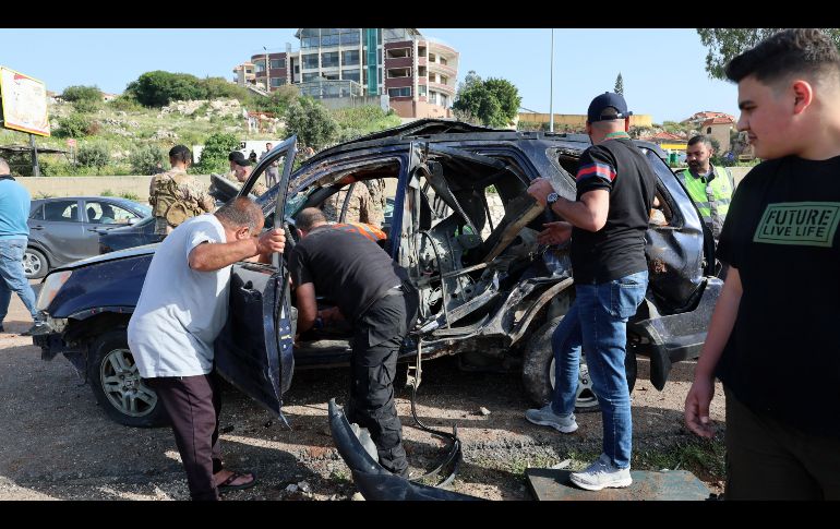 Varias personas trabajan en el lugar de un ataque aéreo israelí que impactó un vehículo en la ciudad de Jiyeh, al sur de Beirut, Líbano. EFE/W. Hamzeh
