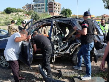 Varias personas trabajan en el lugar de un ataque aéreo israelí que impactó un vehículo en la ciudad de Jiyeh, al sur de Beirut, Líbano. EFE/W. Hamzeh