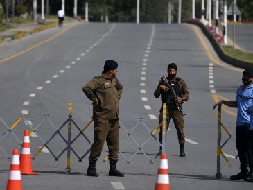 Elementos de seguridad de Pakistán montan guardia en la carretera que lleva a la Zona Roja, donde se ubican la mayoría de las misiones diplomáticas y oficinas gubernamentales, incluyendo la sede prevista para la segunda ronda de conversaciones de paz entre Estados Unidos e Irán. EFE/S. Shahzad
