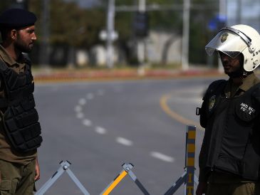 Funcionarios de seguridad paquistaníes montan guardia en una carretera cerca de la sede prevista para la segunda ronda de conversaciones entre EU e Irán. EFE/EPA/S. Shahzadefe