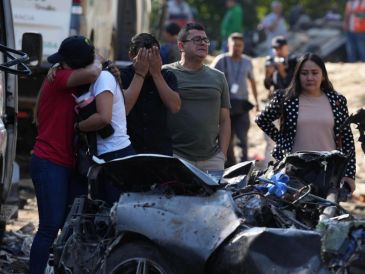 Familiares de las víctimas del atentado ocurrido en la Vía Panamericana lloran este domingo frente a los escombros de los vehículos destruidos en Cajibío, Colombia. EFE/E. Guzmán