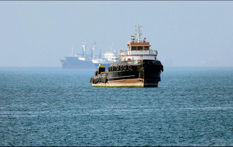 Remolcador iraní navega cerca de un buque anclado en el Estrecho de Ormuz, frente a Bandar Abbas; Teherán niega paso de barcos comerciales. AFP