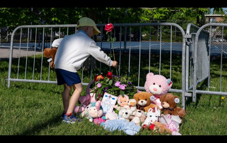 Un niño coloca flores en un altar improvisado en el Parc Ouellette, después de que una niña falleció cuando un castillo inflable fue arrastrado por el viento. AP/C. Muschi