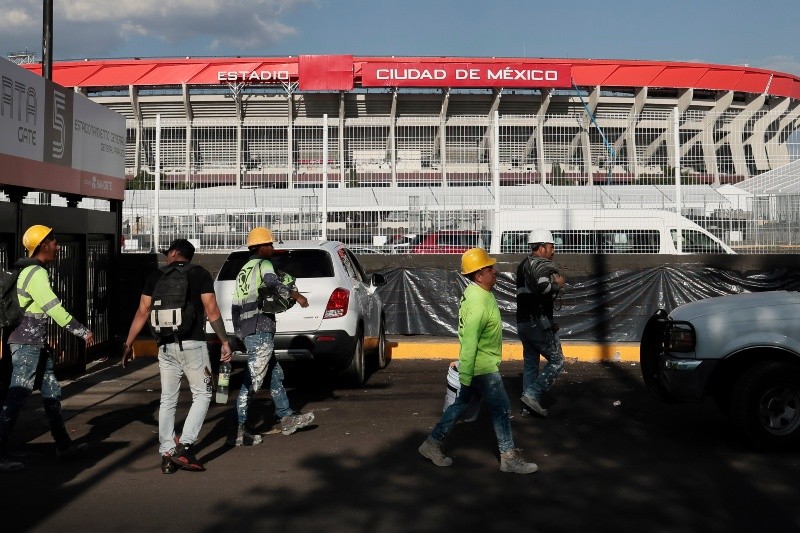 Trabajadores caminan frente al estadio Ciudad de México durante la semana previa a la inauguración del Mundial 2026. EFE / ARCHIVO