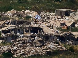Una bandera israelí ondea sobre un edificio destruido en el sur de Líbano, vista desde el norte de Israel. AP/A. Schalit