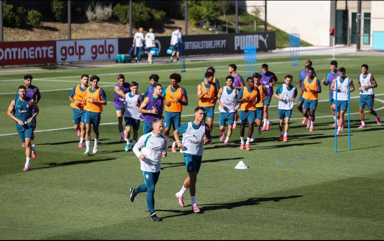 Cristiano Ronaldo y Roberto Martínez corren adelante del resto de la plantilla en el entrenamiento para el juego contra Nigeria. EFE/M. Lopes