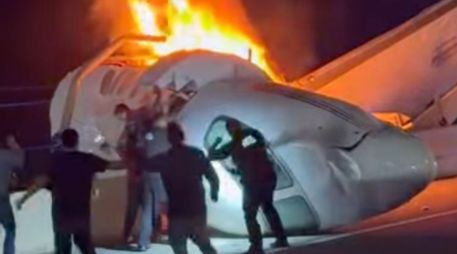 Un pasajero, en la parte superior de la imagen, salta de un avión que se estrelló en una autopista de Texas mientras otras personas ayudan. AP/Z. Garza