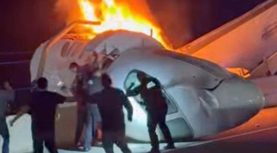 Un pasajero, en la parte superior de la imagen, salta de un avión que se estrelló en una autopista de Texas mientras otras personas ayudan. AP/Z. Garza