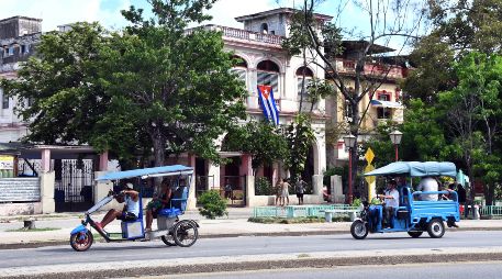 Imagen del 18 de junio de 2026 de pasajeros viajando a bordo de triciclos eléctricos por una avenida en La Habana, Cuba. XINHUA/J. Hernández